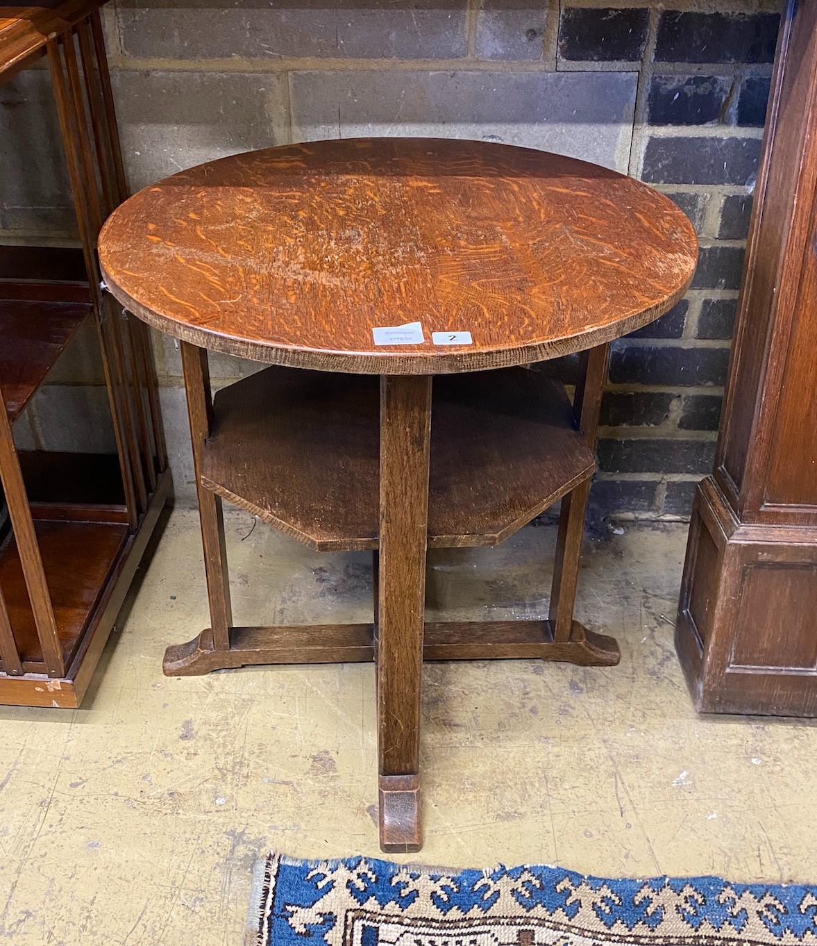 An Arts & Crafts circular oak two tier occasional table, diameter 61cm, height 61cm